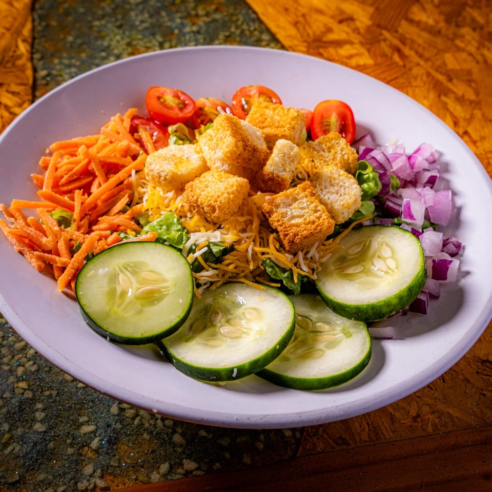 Breaded tofu cubes served over rice and greens with cucumber, shredded carrots, tomatoes, jalapeño, and red onion.